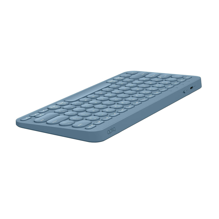Stijlvol, compact blauw draadloos Bluetooth toestenbord, afgeronde hoeken en ronde toetsen, opladen met USB-C, liggend schuin van achteren gezien op witte achtergrond