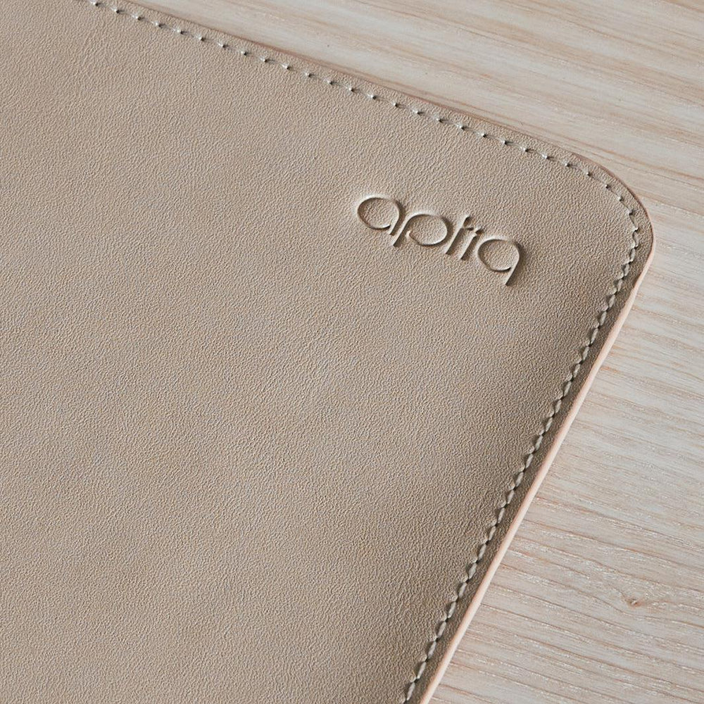 Close-up van hoek van Aptiq bureau onderlegger in sand kleur met logo in beeld