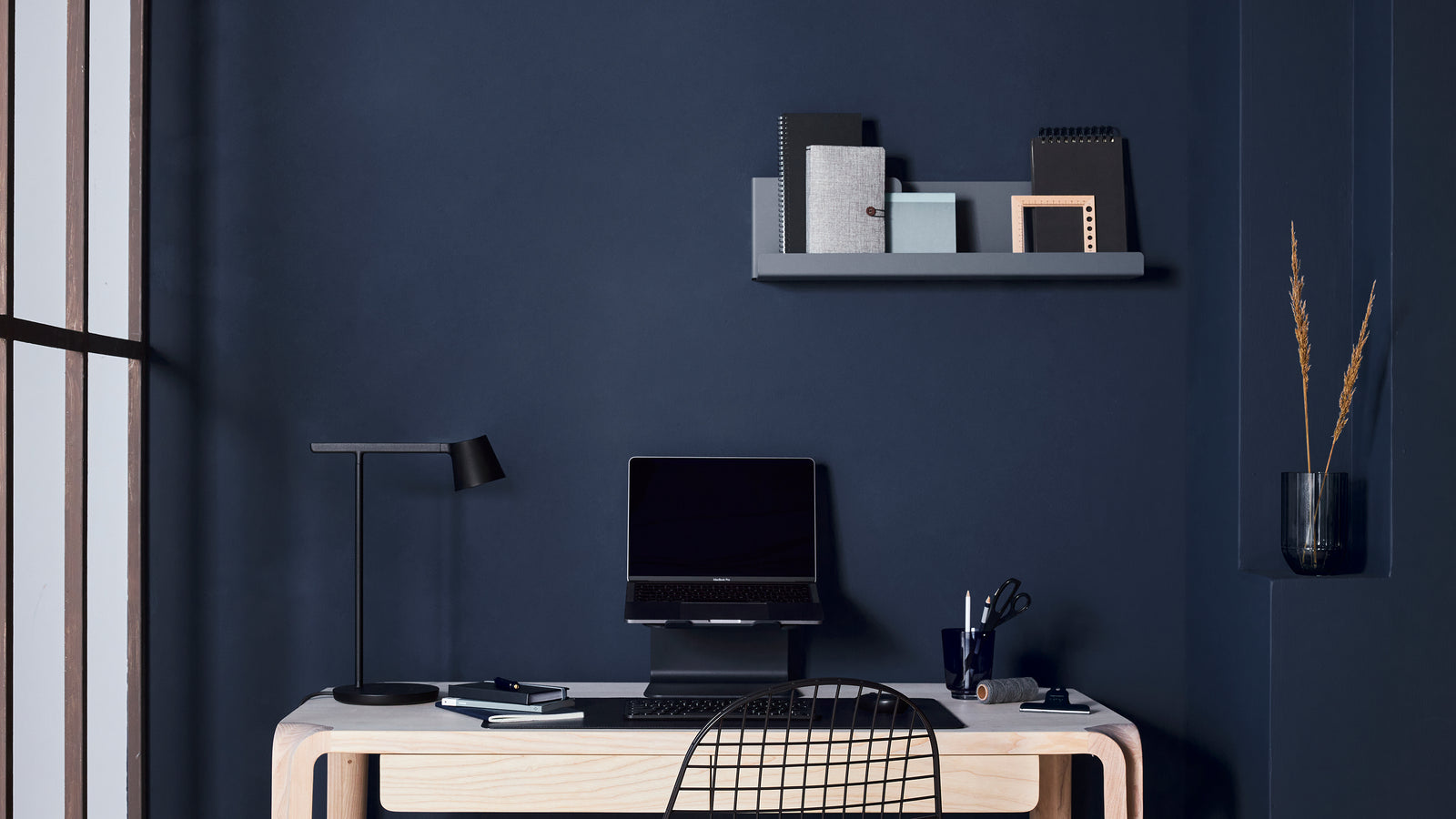 Donkerblauwe werkplek met laptop en bijpassende Aptiq accessoires
