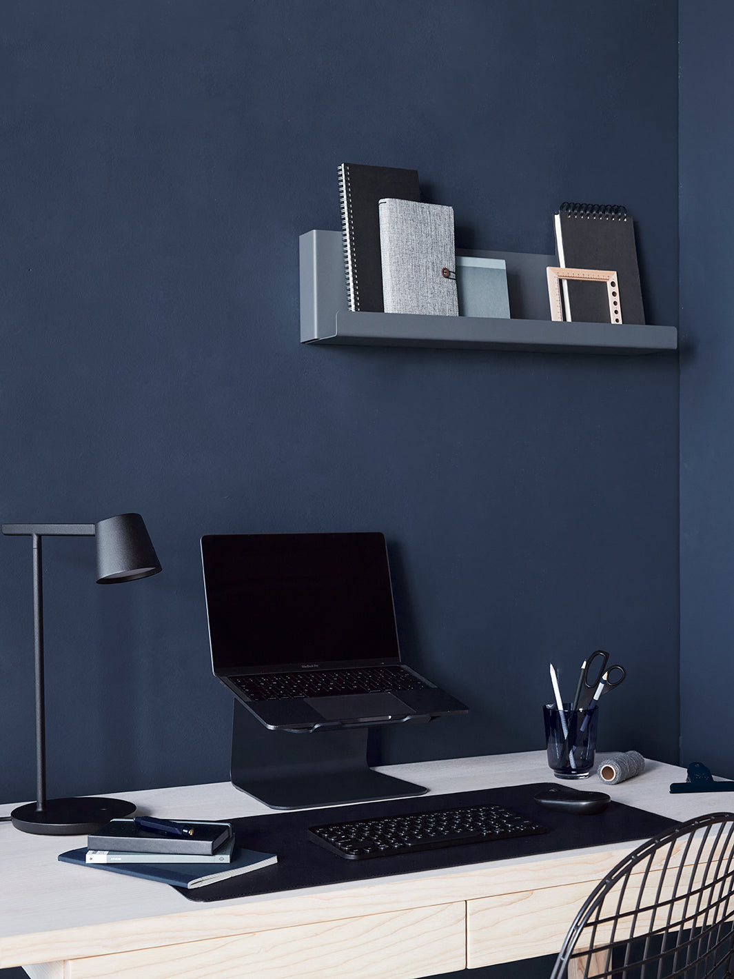 Donker blauwe werkplek met laptop en Aptiq bureau accessoires in midnight blue