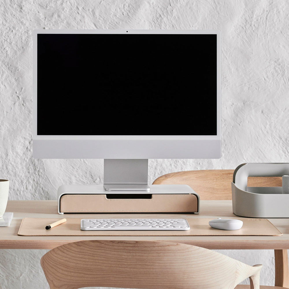 Werkplek aan tafel met een monitor standaard in wit met een lade in sand kleur