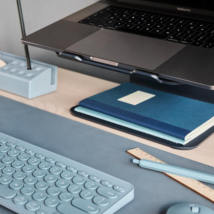 Close-up van een blauwe laptopstandaard met blauwe bureau accessoires