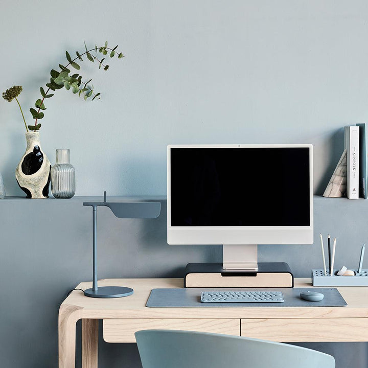 Werkplek in blauw tinten met een monitor op blauwe monitorstandaard met een lade in de kleur sand