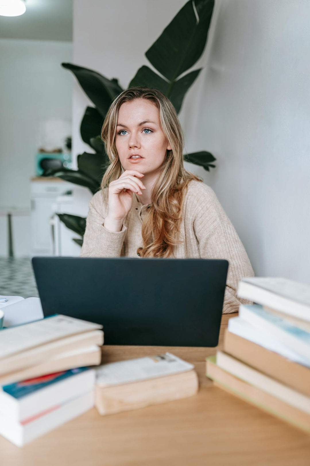 Vrouw zit achter laptop te denken over inrichting werkplek